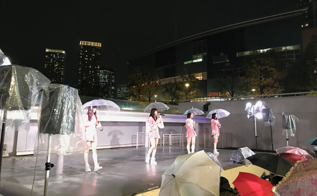 「東京女子流」が雨中に傘を差して2曲を歌声だけで披露
